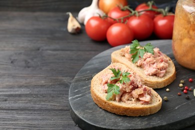 Photo of Sandwiches with canned meat served on wooden table, closeup. Space for text