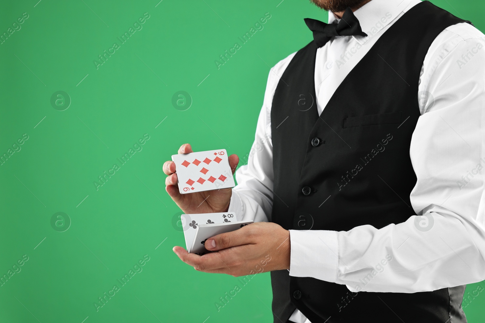 Photo of Professional croupier shuffling cards on green background, closeup. Space for text