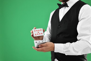 Professional croupier shuffling cards on green background, closeup. Space for text