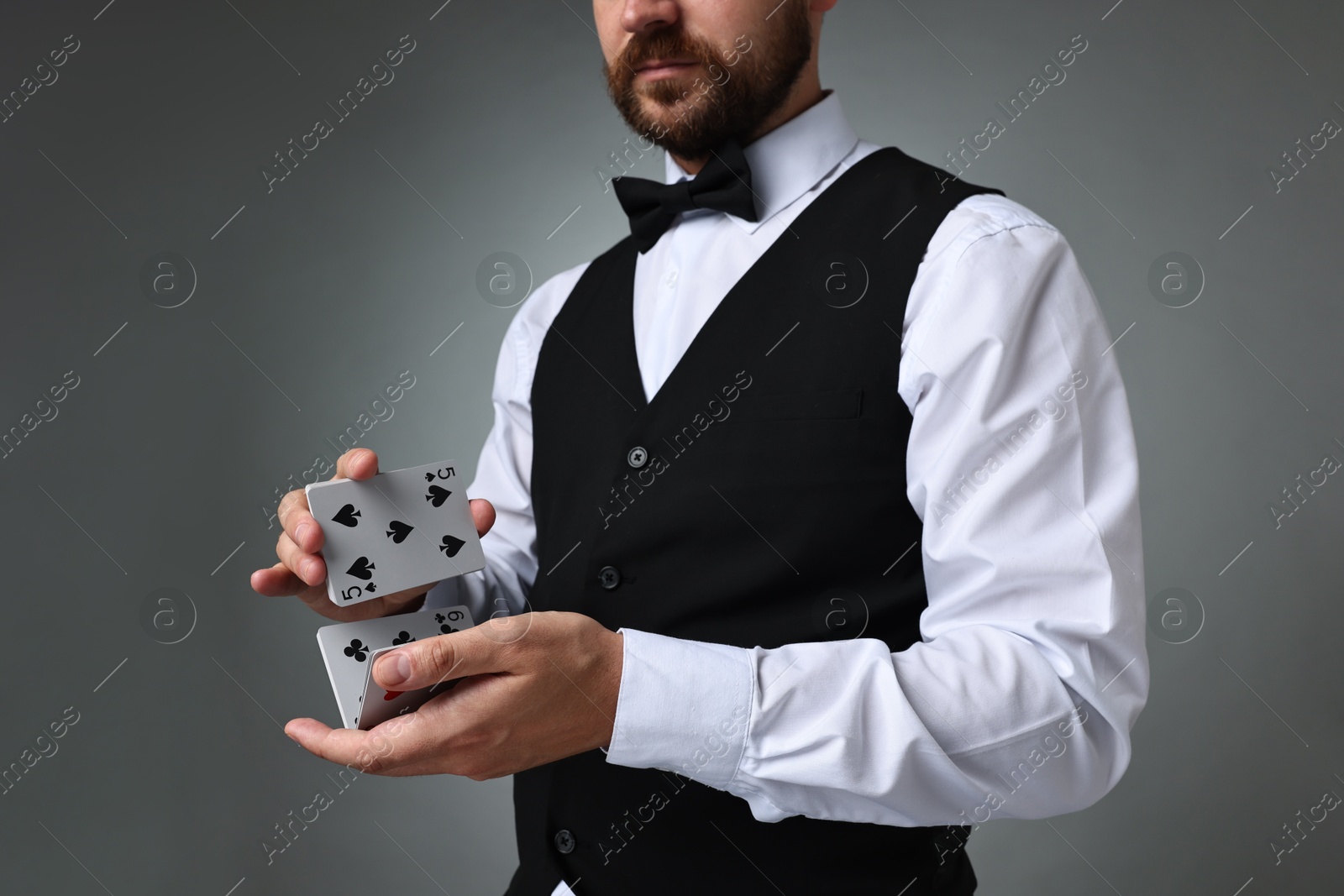 Photo of Professional croupier shuffling cards on grey background