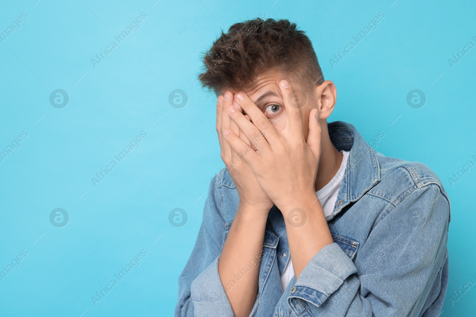 Photo of Portrait of scared young man on light blue background, space for text