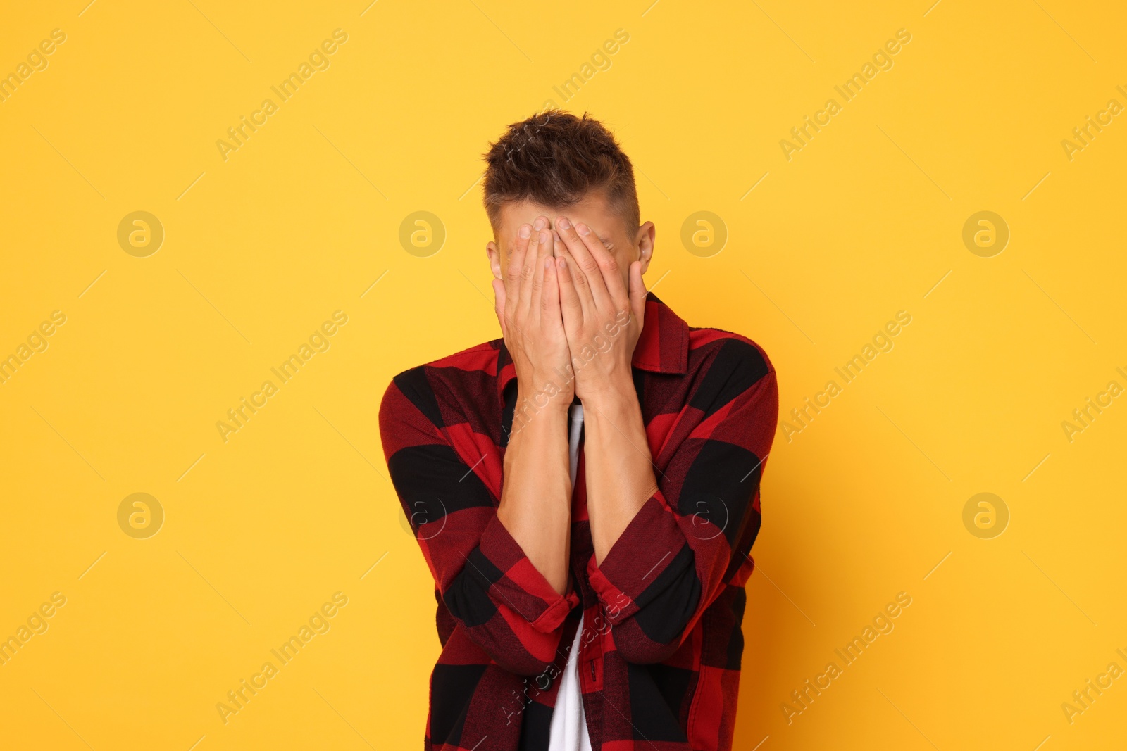 Photo of Portrait of scared young man on orange background