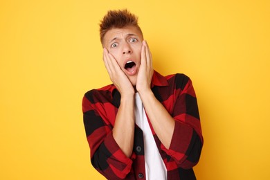 Photo of Portrait of scared young man on orange background