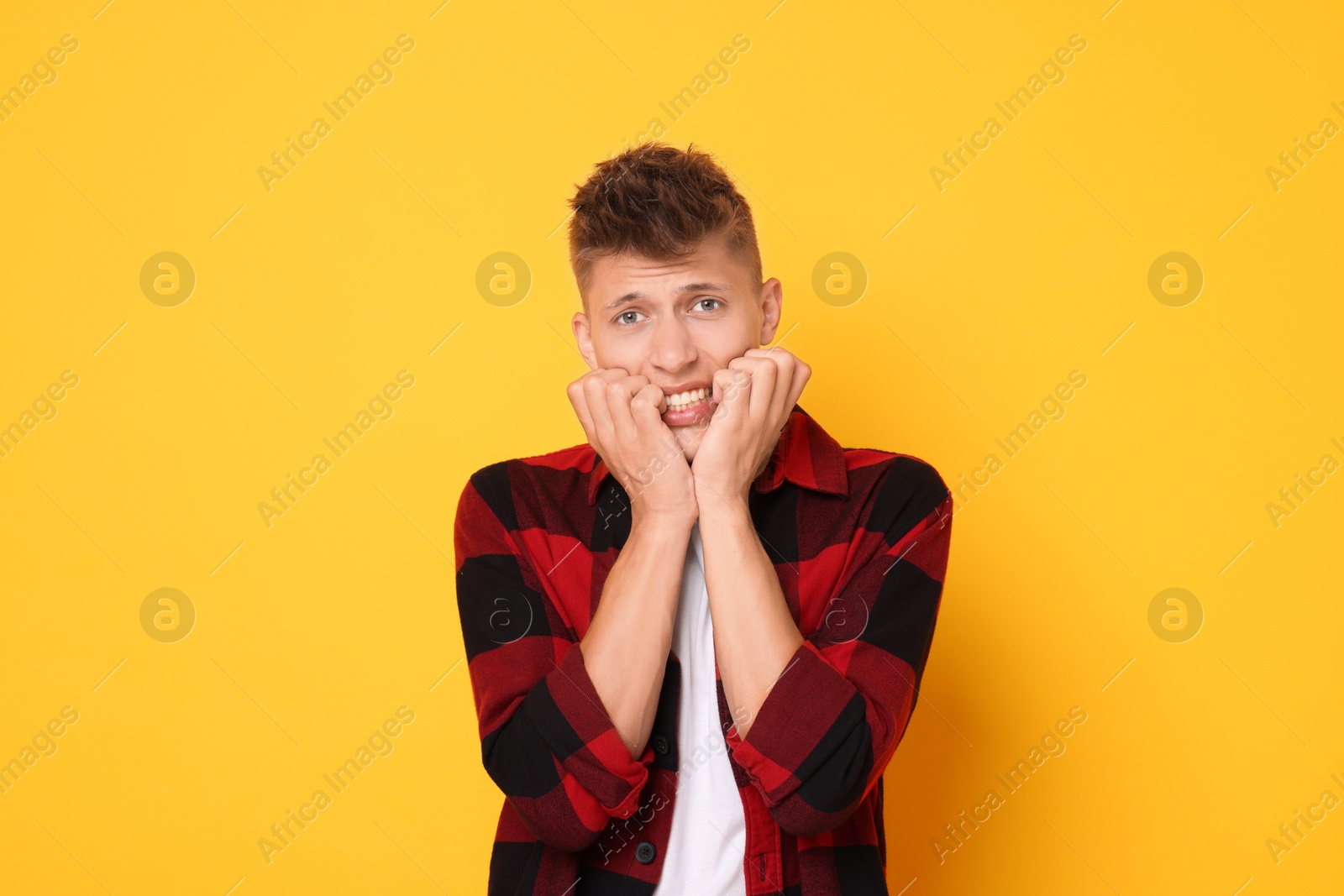 Photo of Portrait of scared young man on orange background