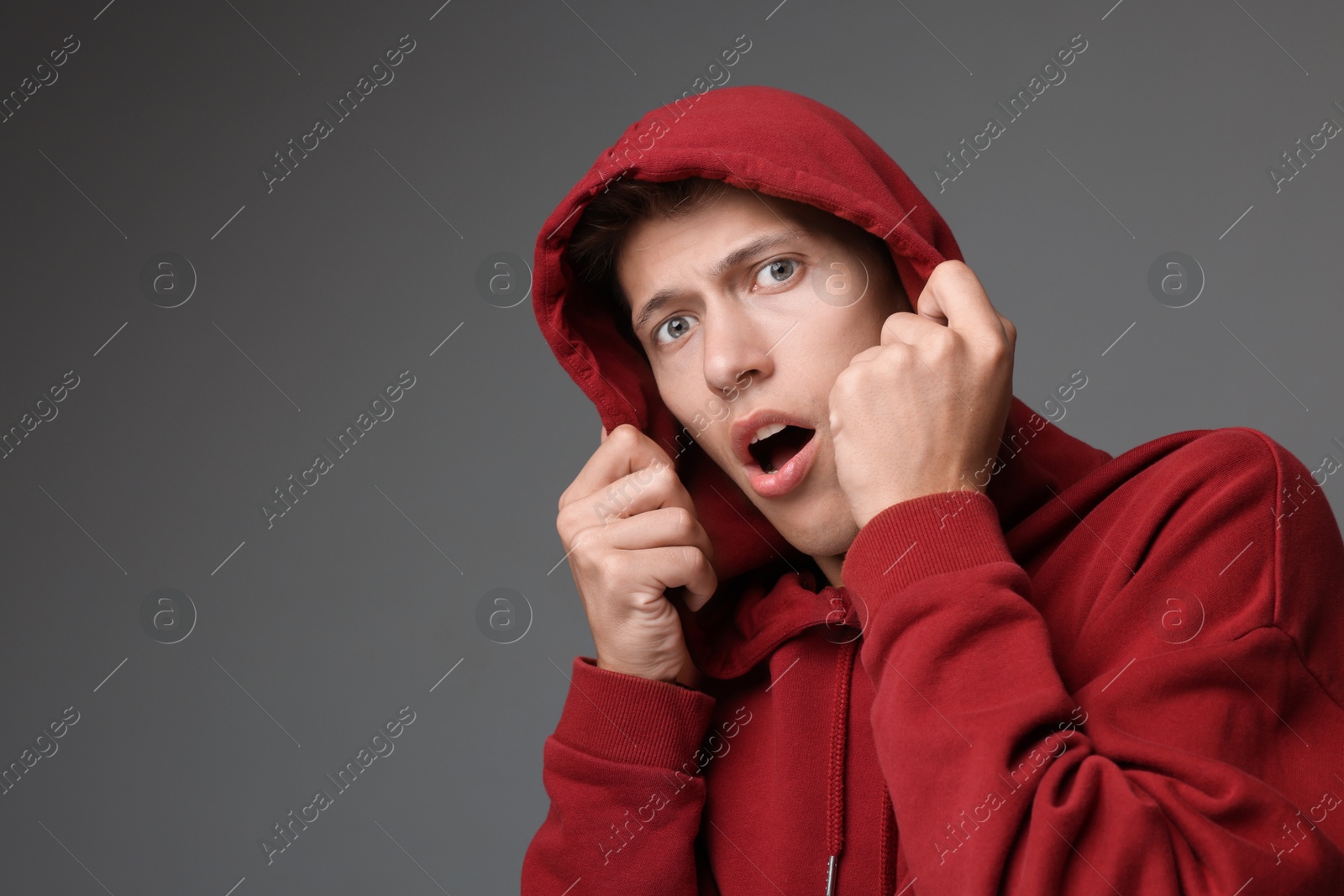 Photo of Portrait of scared young man on gray background, space for text