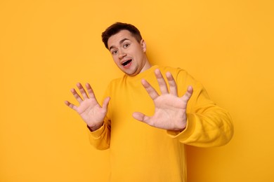 Photo of Portrait of scared young man on orange background