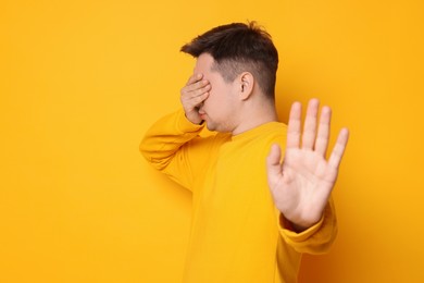 Photo of Portrait of scared young man on orange background