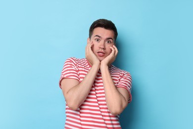 Photo of Portrait of scared young man on light blue background