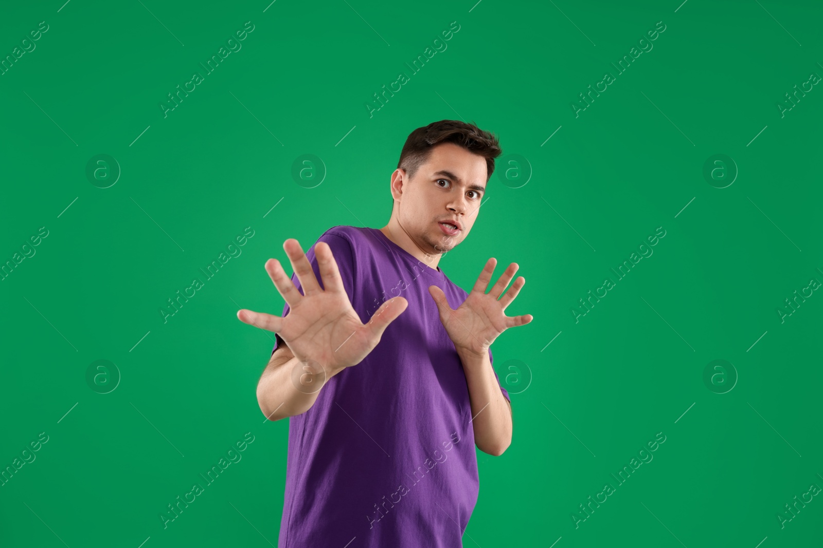 Photo of Portrait of scared young man on green background