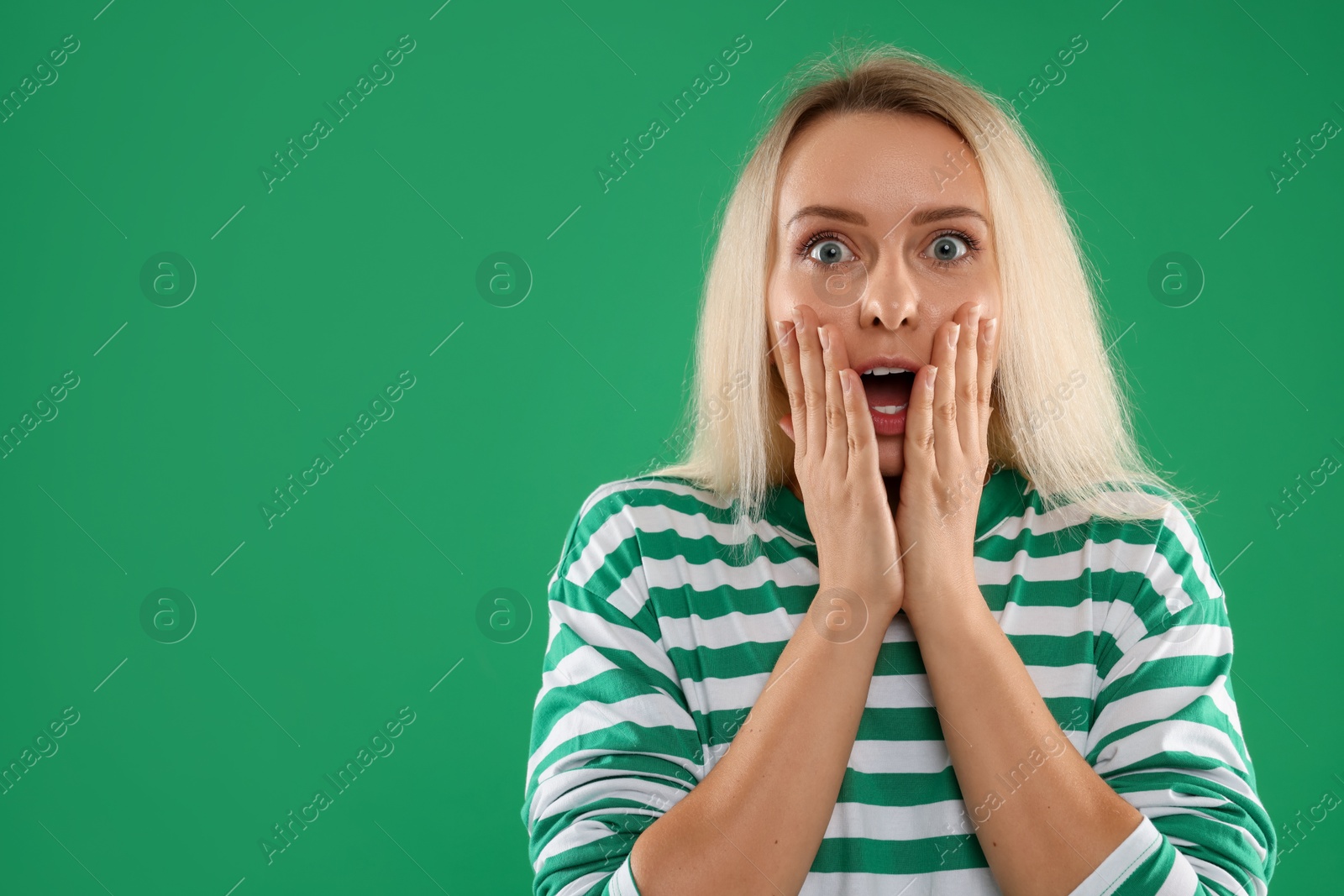 Photo of Portrait of scared woman on green background, space for text