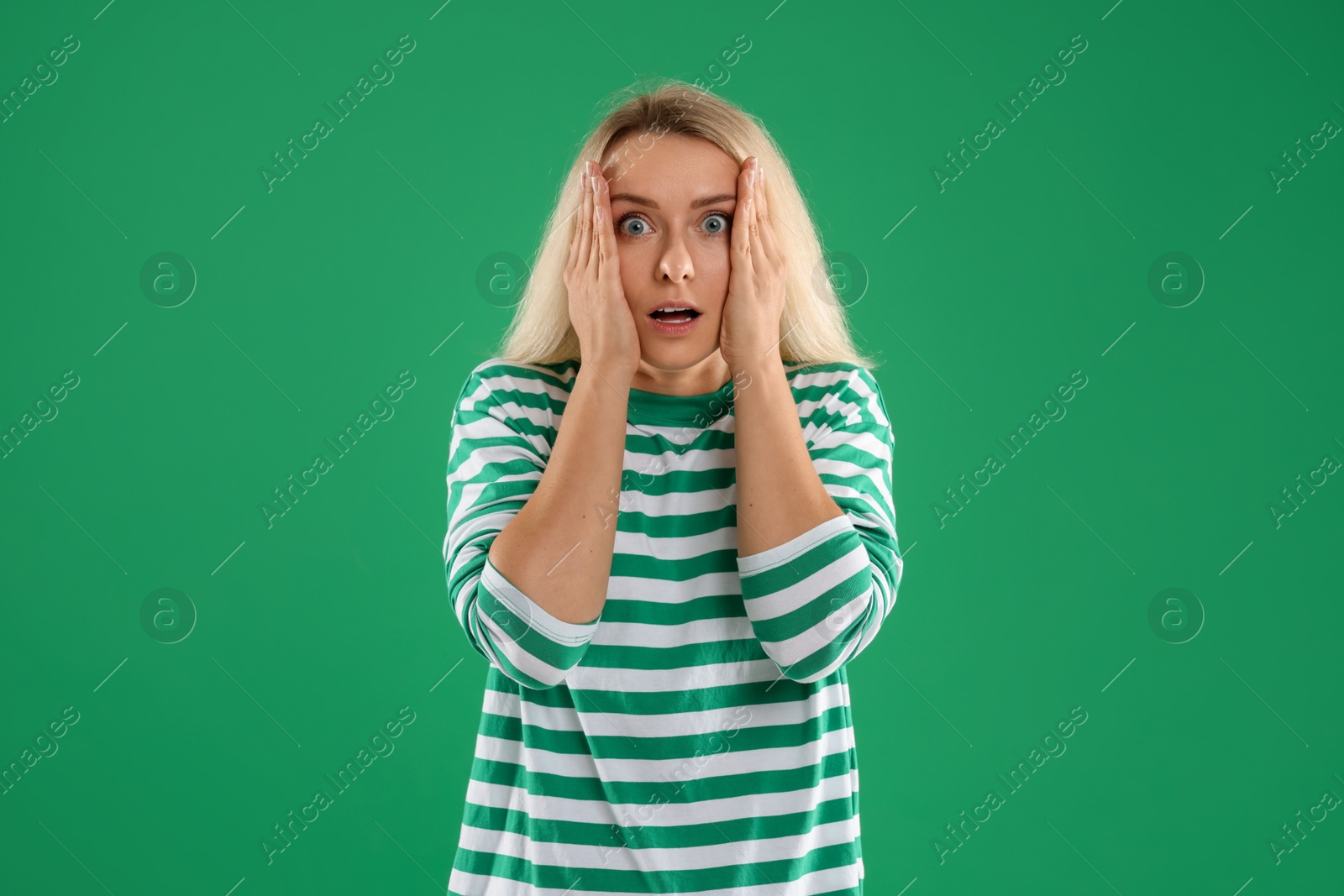 Photo of Portrait of scared woman on green background