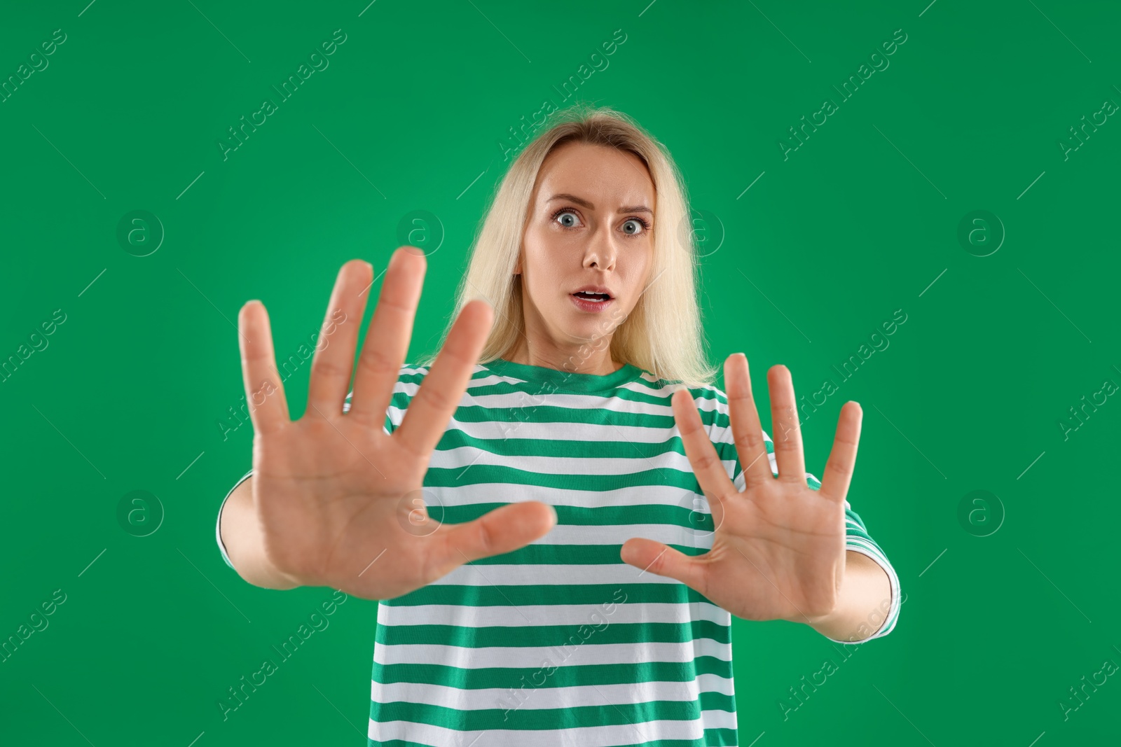 Photo of Portrait of scared woman on green background