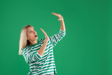 Portrait of scared woman on green background, space for text