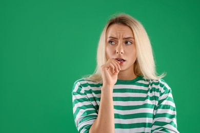 Photo of Portrait of scared woman on green background, space for text