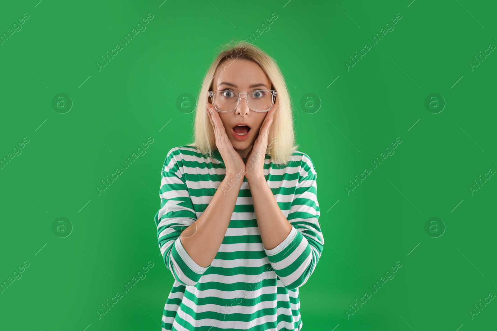 Photo of Portrait of scared woman on green background