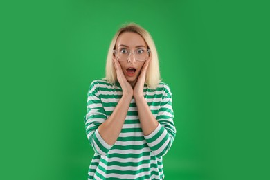 Photo of Portrait of scared woman on green background