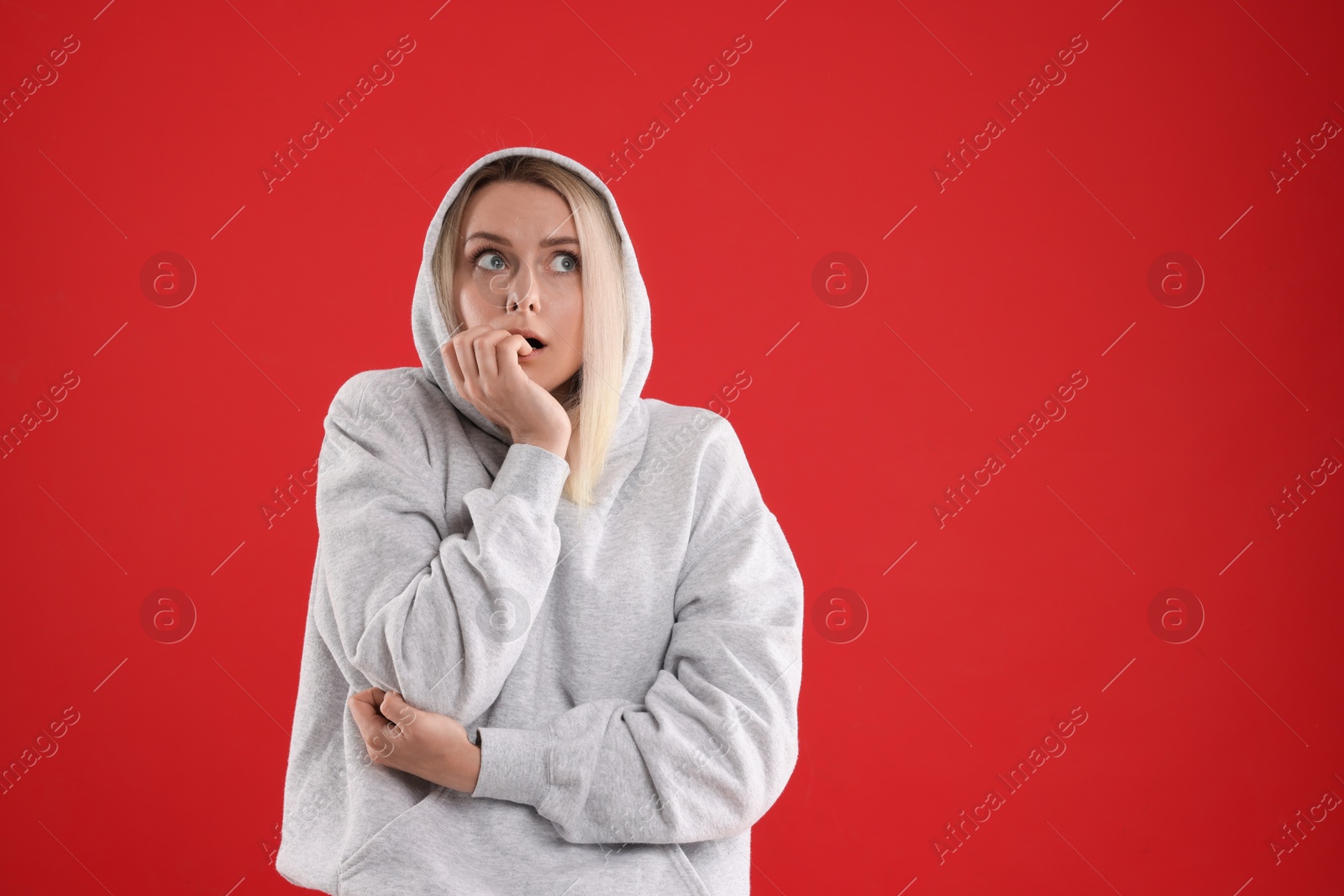 Photo of Portrait of scared woman on red background, space for text