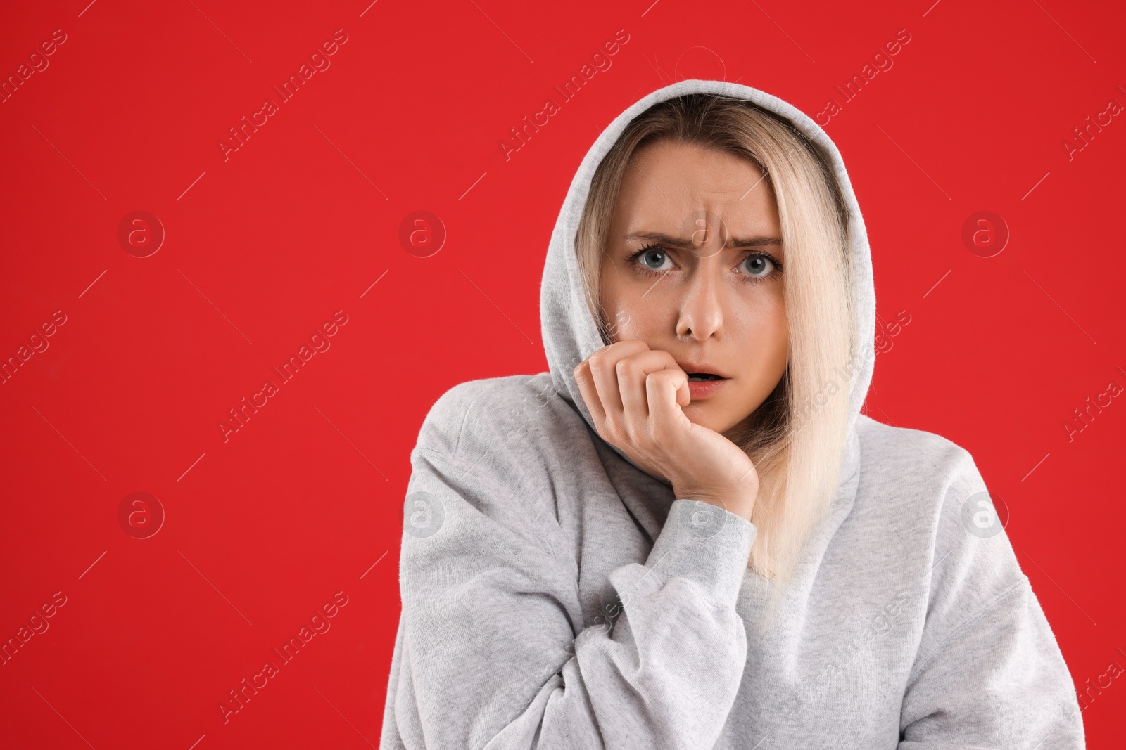 Photo of Portrait of scared woman on red background, space for text