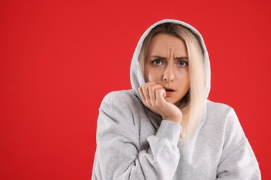 Photo of Portrait of scared woman on red background, space for text