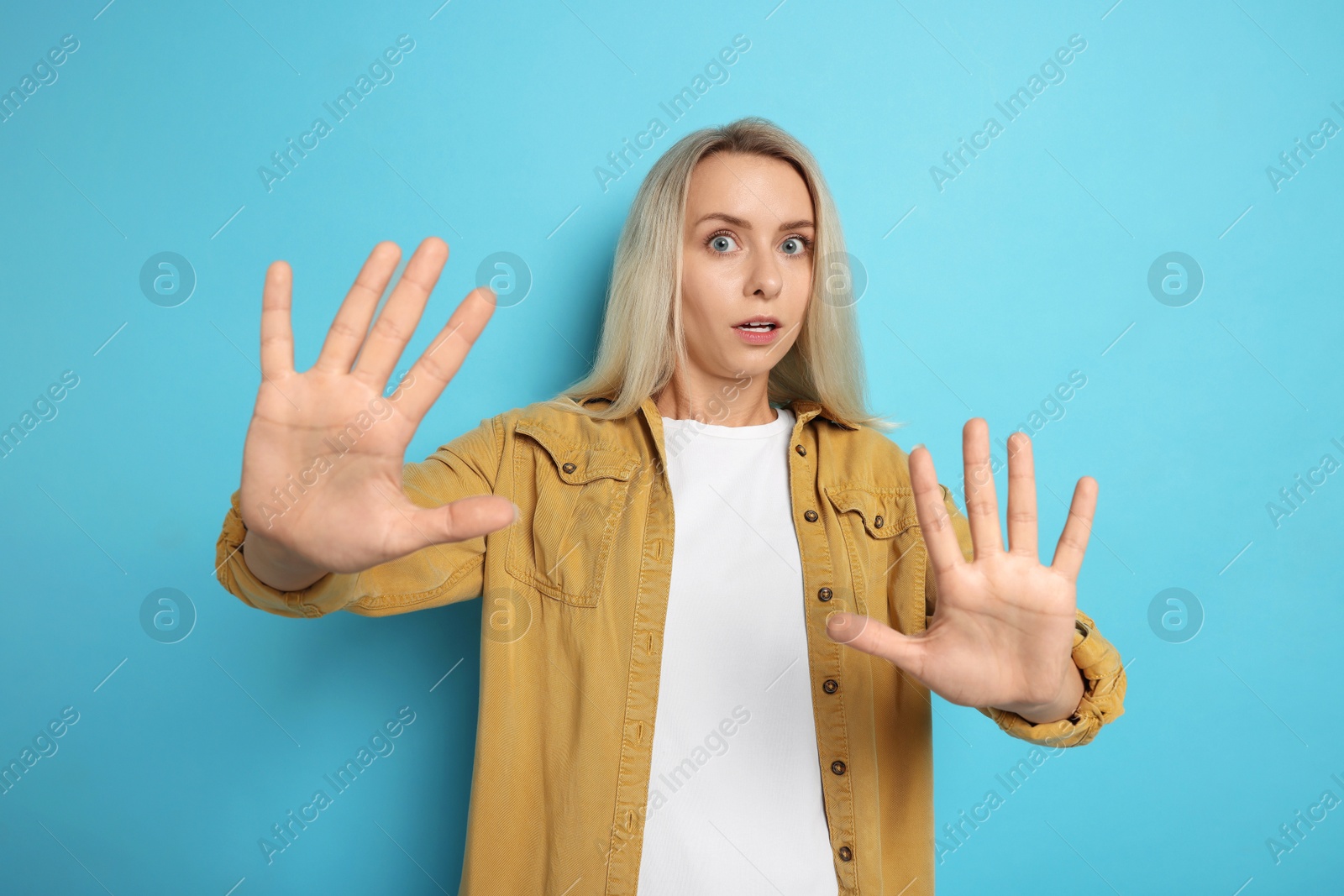 Photo of Portrait of scared woman on light blue background