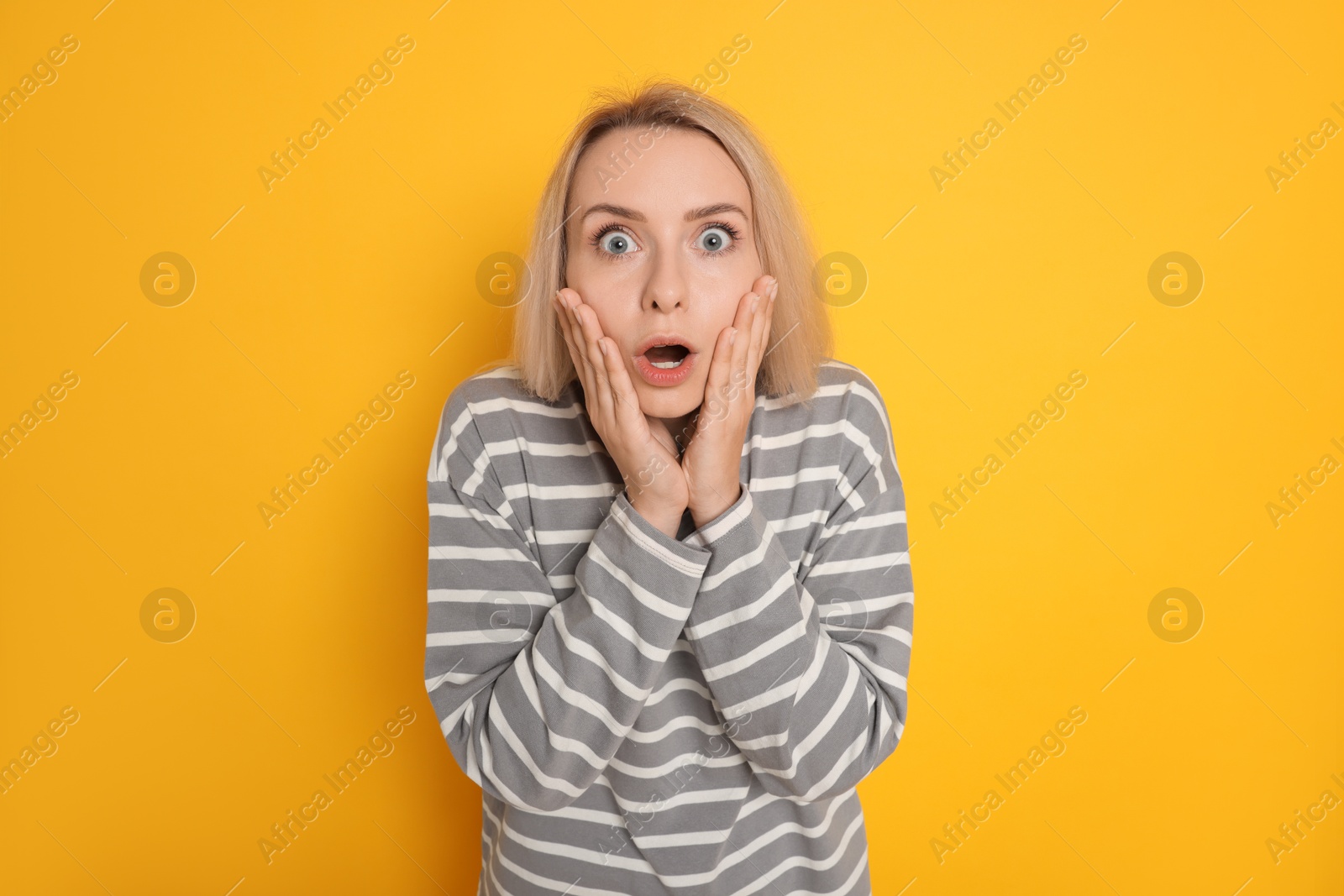 Photo of Portrait of scared woman on orange background