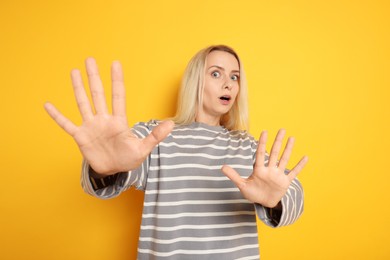 Portrait of scared woman on orange background