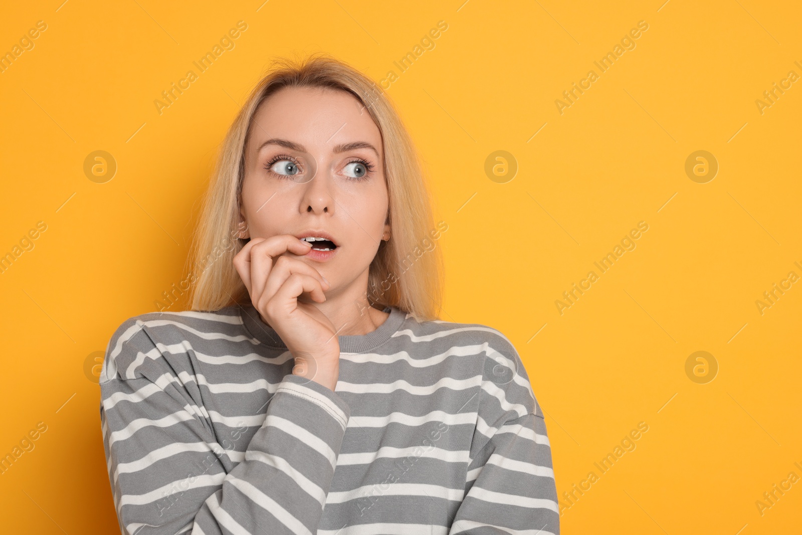 Photo of Portrait of scared woman on orange background, space for text