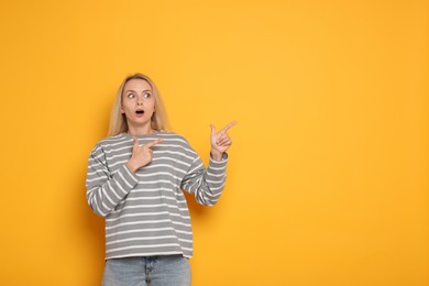 Portrait of scared woman on orange background, space for text