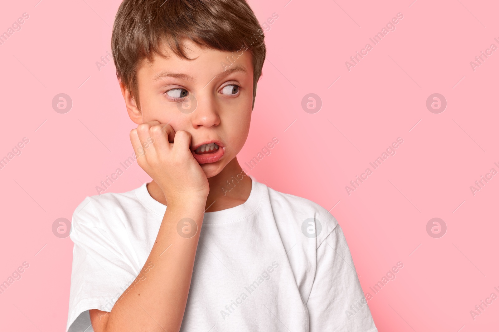 Photo of Portrait of scared little boy on pink background