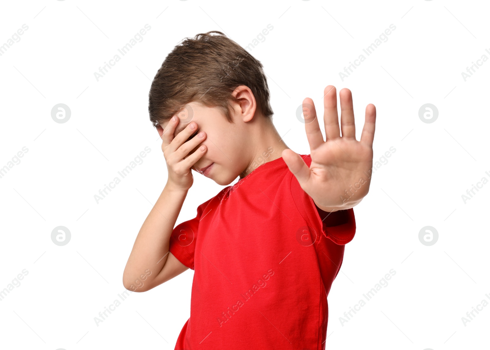 Photo of Scared little boy covering eyes on white background