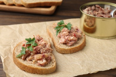 Sandwiches with canned meat and parsley on table, closeup