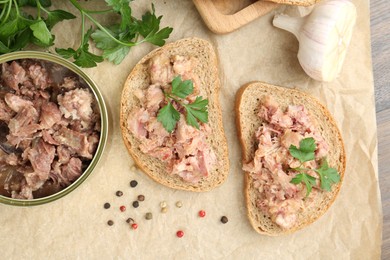 Photo of Sandwiches with canned meat, parsley, garlic and peppercorns on table, top view