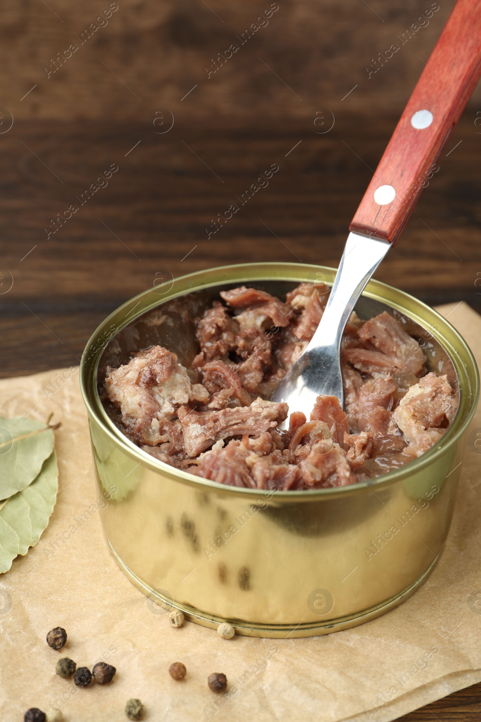 Photo of Canned meat in tin can on table, closeup