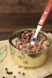 Photo of Canned meat in tin can on table, closeup