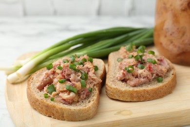 Photo of Sandwiches with canned meat and green onions on table, closeup