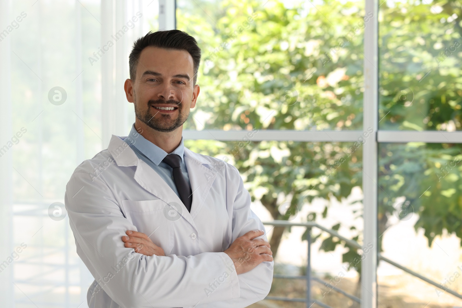 Photo of Portrait of smiling doctor indoors, space for text