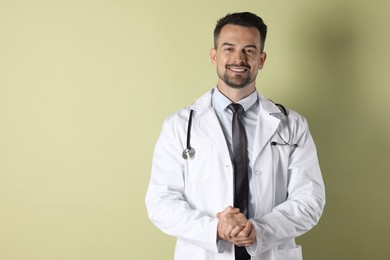 Smiling doctor with stethoscope on olive background. Space for text