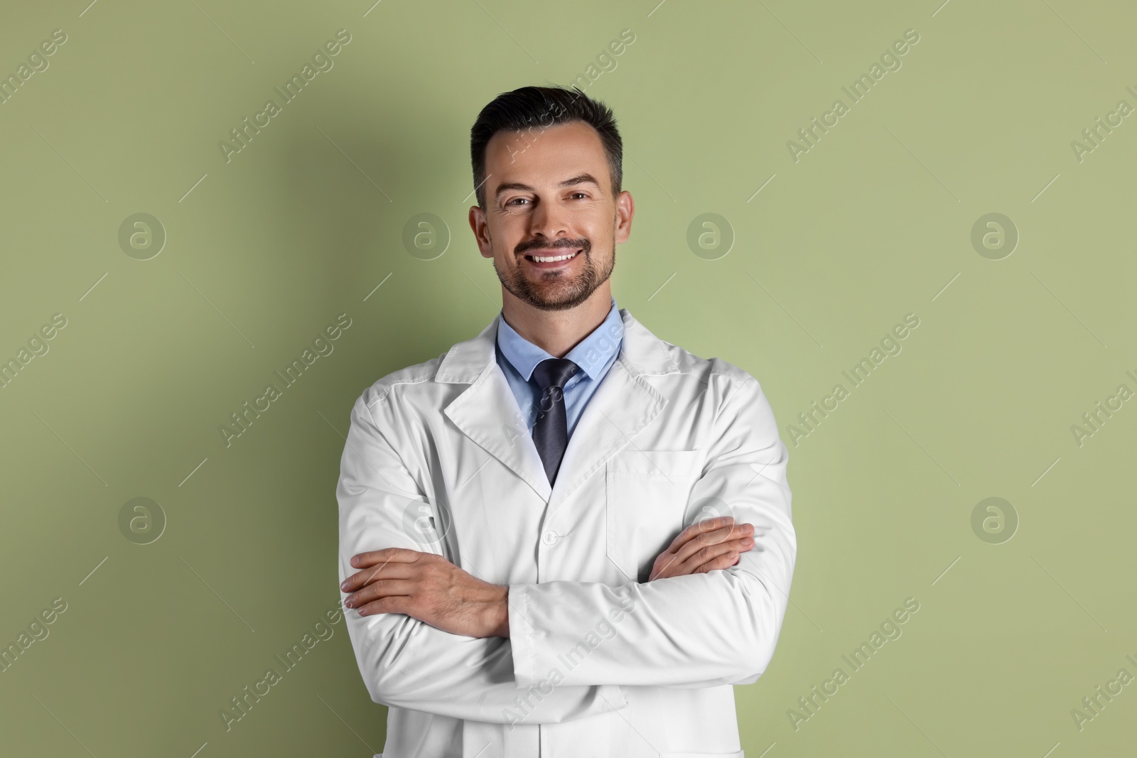 Photo of Portrait of smiling doctor on olive background