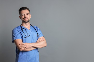 Smiling nurse with stethoscope on grey background, space for text