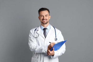 Smiling doctor with stethoscope and clipboard on grey background