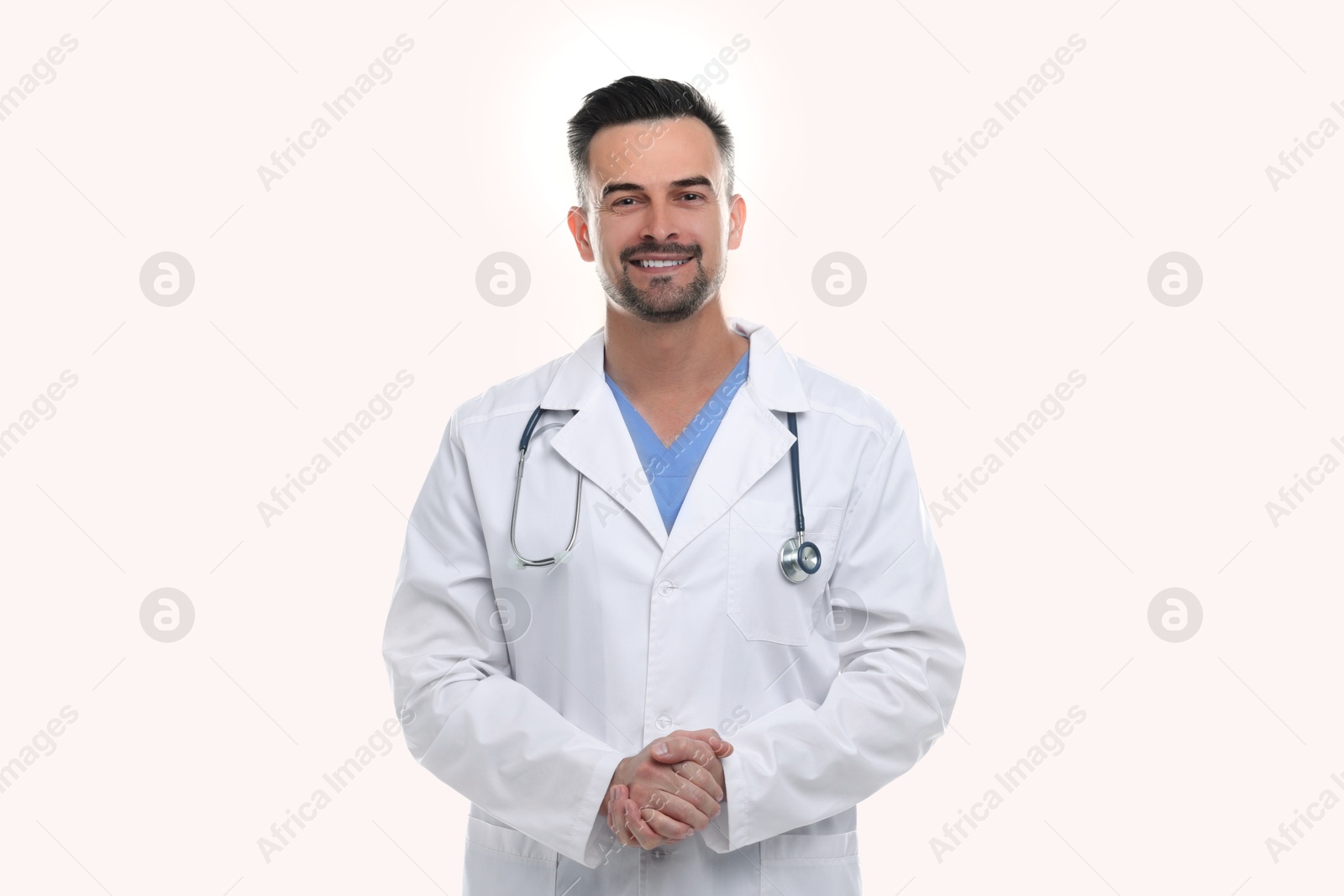 Photo of Smiling doctor with stethoscope on white background