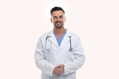 Smiling doctor with stethoscope on white background