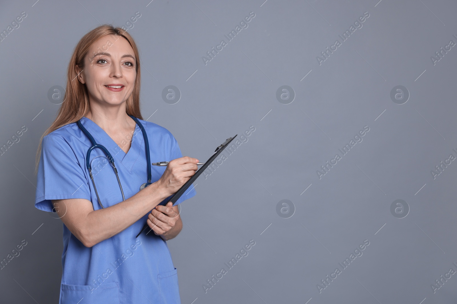 Photo of Doctor with clipboard writing notes on gray background, space for text