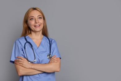 Doctor with stethoscope on gray background, space for text