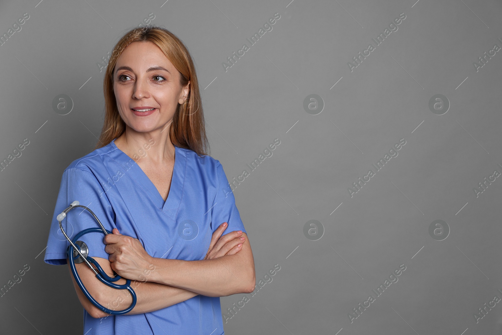 Photo of Doctor with stethoscope on gray background, space for text