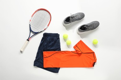 Photo of Tennis racket, balls, sneakers and sportswear on light background, flat lay