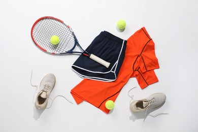 Photo of Tennis racket, balls, sneakers and sportswear on light background, flat lay