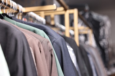 Many different clothes hanging from rack in professional workshop, closeup