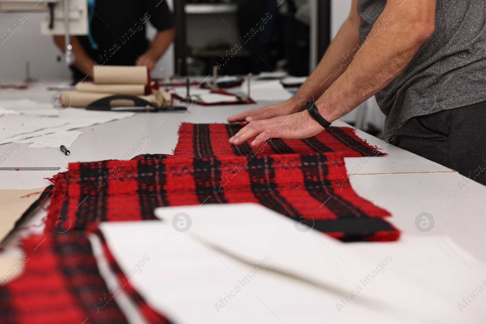 Photo of Man working at white table in professional workshop, closeup