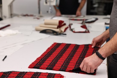 Photo of Man working at white table in professional workshop, closeup